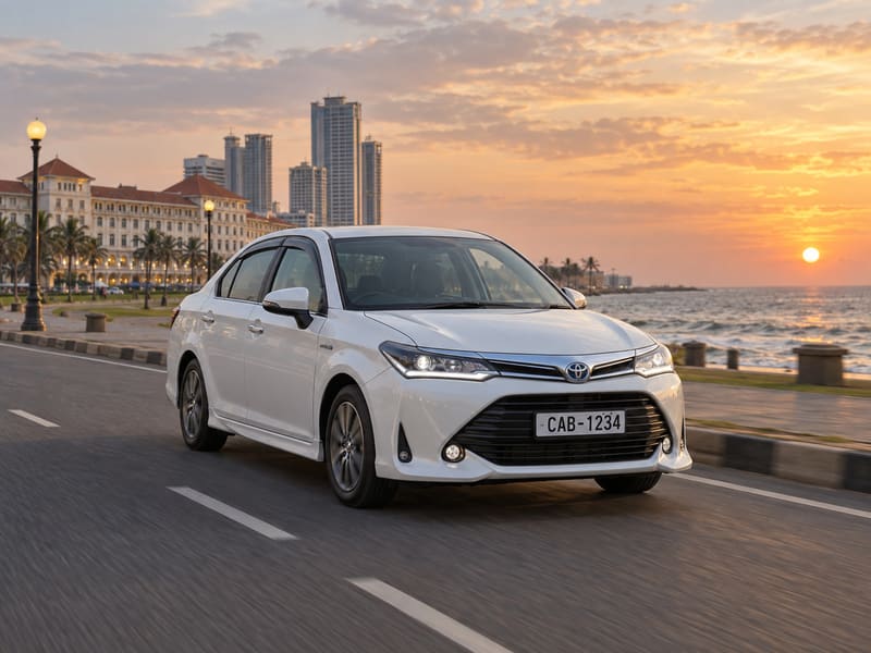 White Toyota Corolla Axio hybrid driving along the Colombo seafront at sunset.